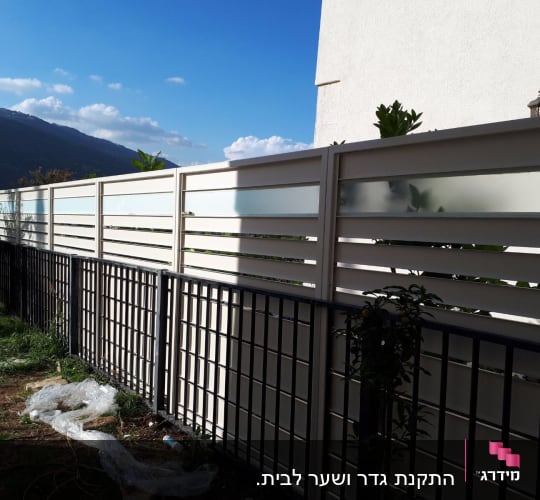 גדרות מתכת ולוחות זכוכית חלבית בחצר
